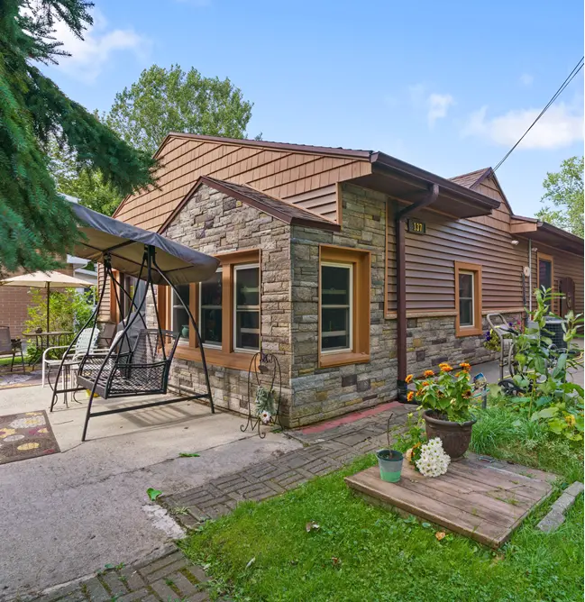 Completed siding remodel in Lansing MI featuring CertainTeed Monogram vinyl siding and Versetta Stone veneer.