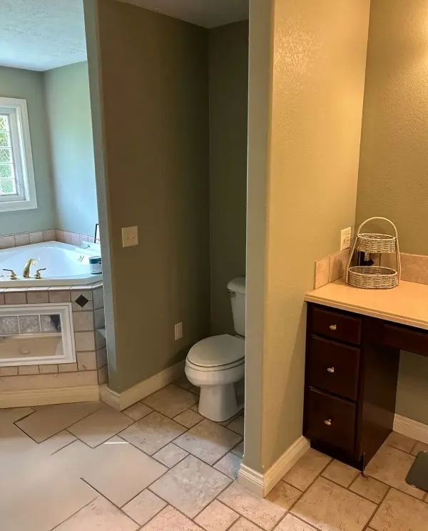 Original toilet alcove and dated cabinetry prior to Traverse City bathroom remodel.