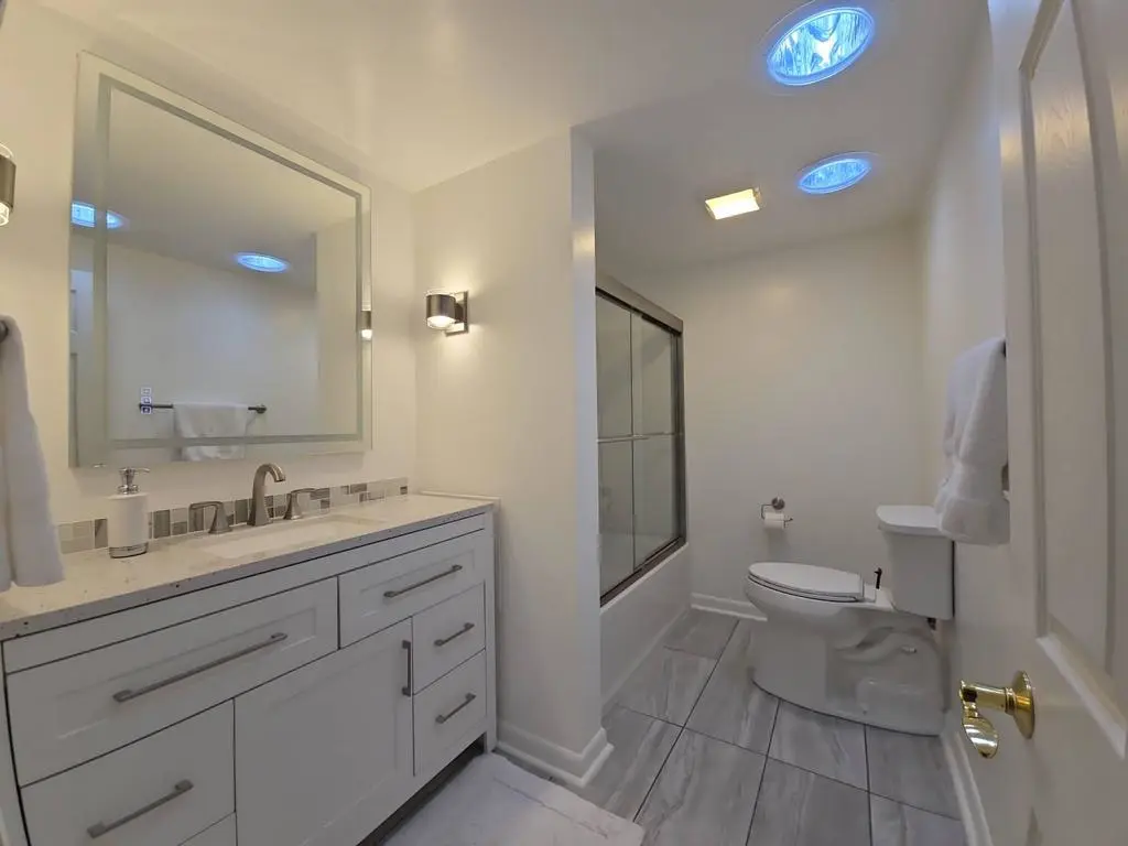 Renovated bathroom featuring new Kohler toilet and Velux Sun Tunnel for natural light