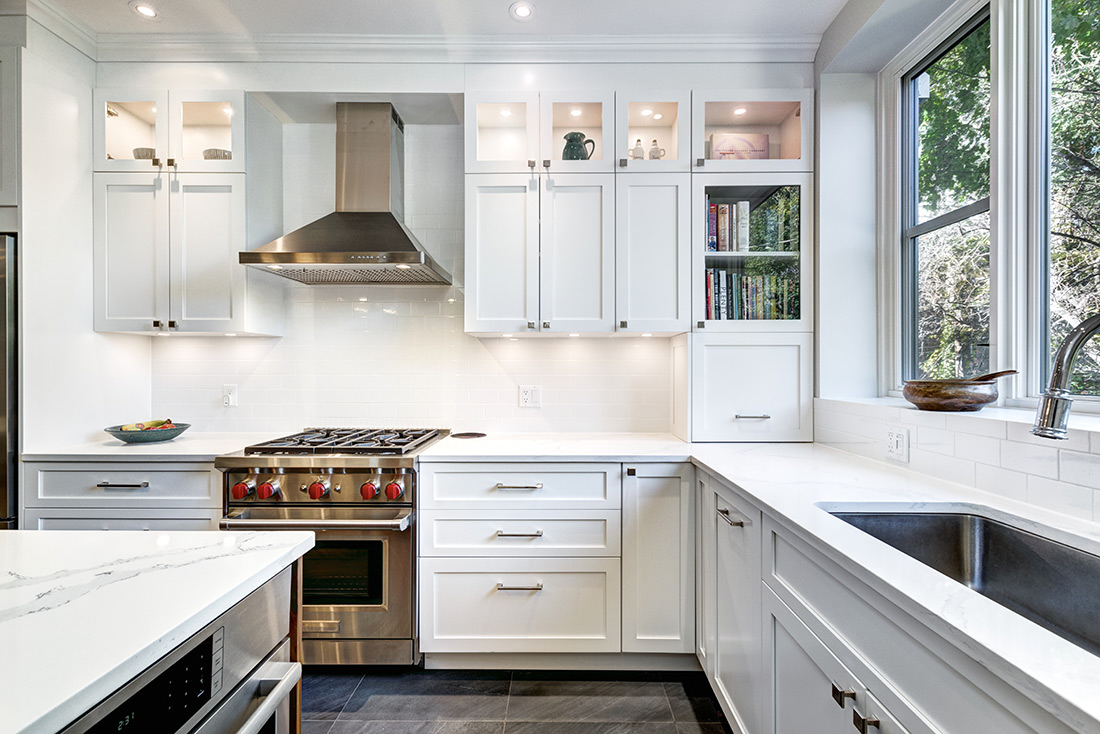 A modern kitchen remodel in Ada Township, Michigan, with white kitchen cabinets of solid-wood construction, stainless steel appliances, and dark tile flooring.