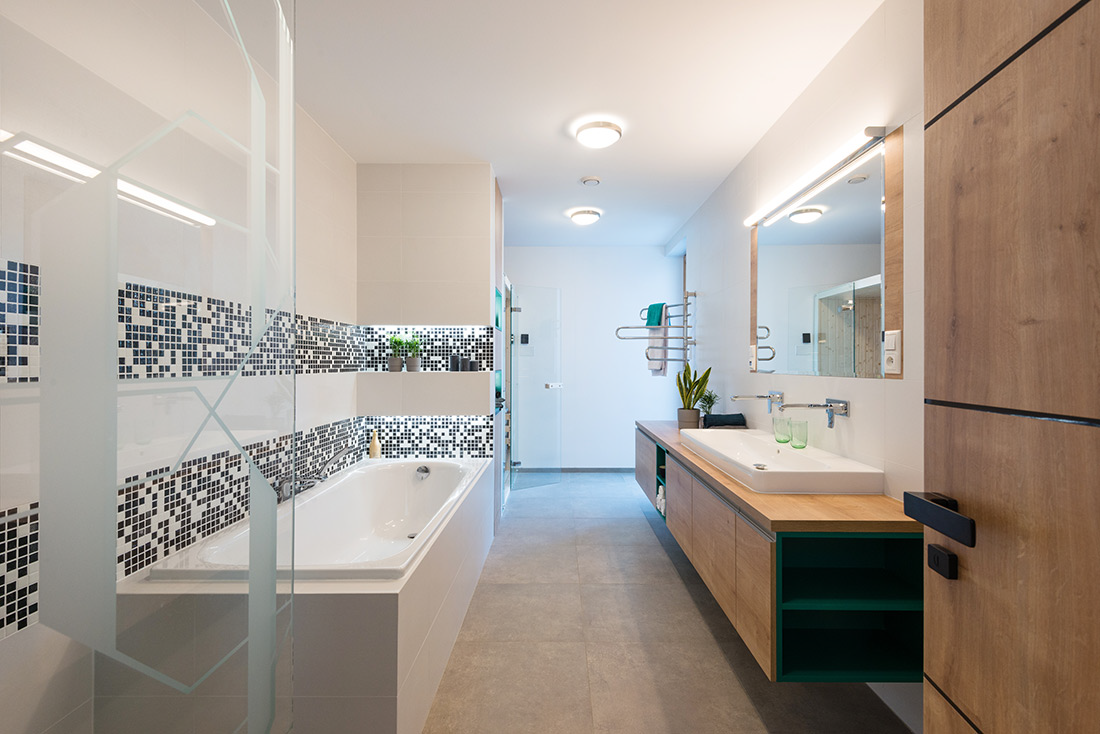Modern bathroom remodel in Ada Township, Michigan, with a soaking tub, walk-in shower, ceramic tile floor, mosaic ceramic wall tiles, and a floating vanity with a granite top.