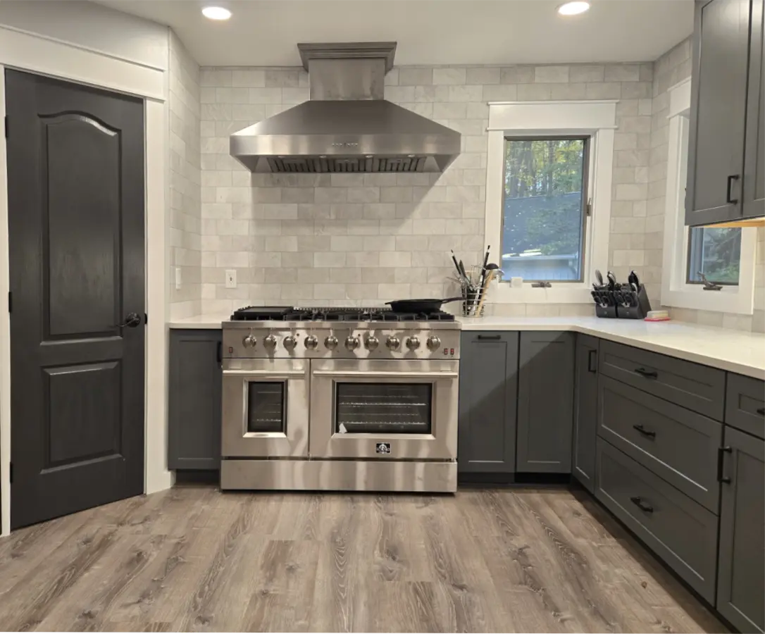 After kitchen remodel in Brighton MI featuring modern grey cabinets, white quartz countertops, and subway tile backsplash.