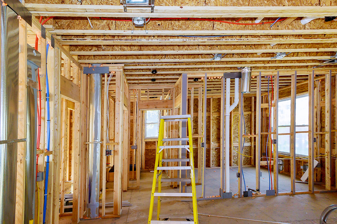 Interior wood framing for a new home construction project in Ada Township, Michigan, showing the electrical and plumbing rough-in.