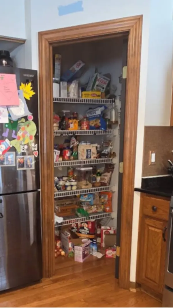 Cluttered pantry with basic wire shelving before renovation in Brighton MI.
