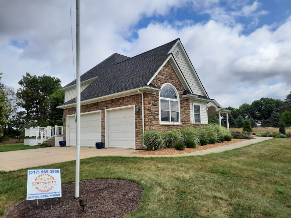 House in Mason, Michigan, featuring Versetta stone veneer, CertainTeed vinyl siding, and fiber cement siding, and a large arched Home Depot window.