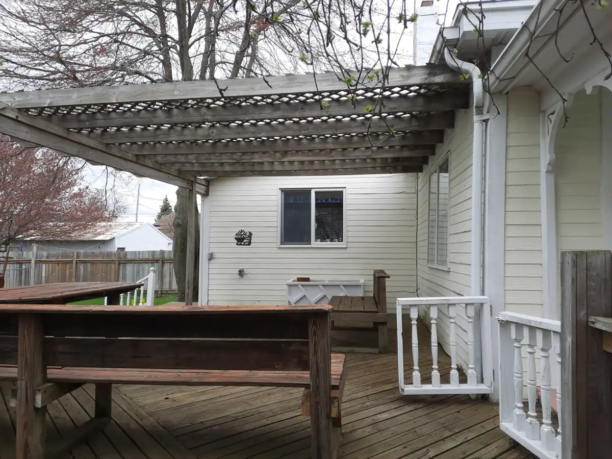 Close up of rotted wood bench and grey decking requiring removal by home improvement contractors.