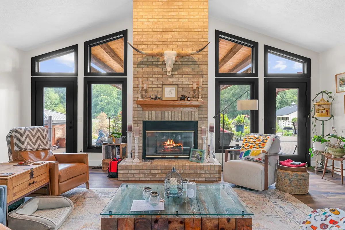 Expansive living room with vaulted ceilings featuring a wall of new black windows and patio doors installed by local contractors.