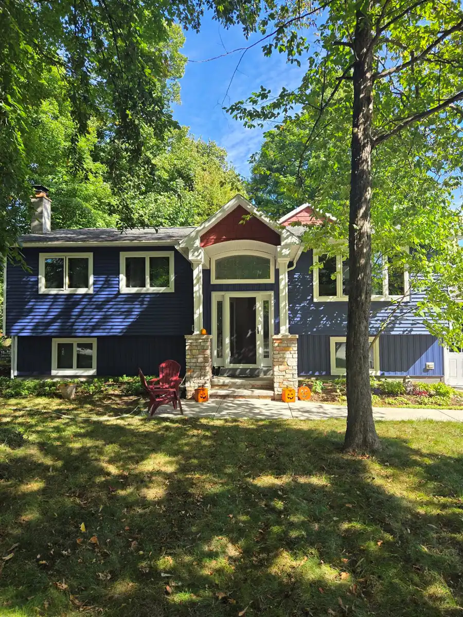 Front of house after installation by insulated vinyl siding installers featuring versetta stone