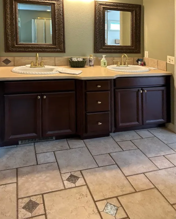 Dark, outdated wood bathroom vanities and brass fixtures before renovation.
