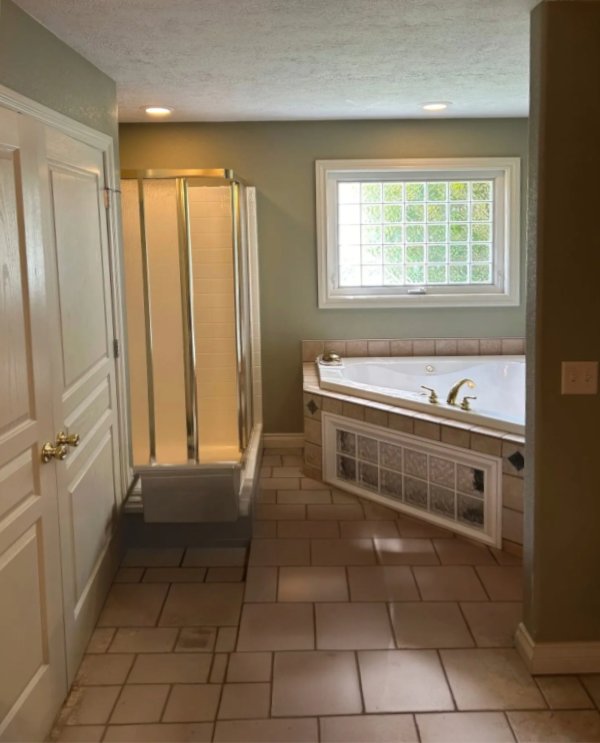 Old, cramped plastic shower insert before walk-in shower installation Michigan.