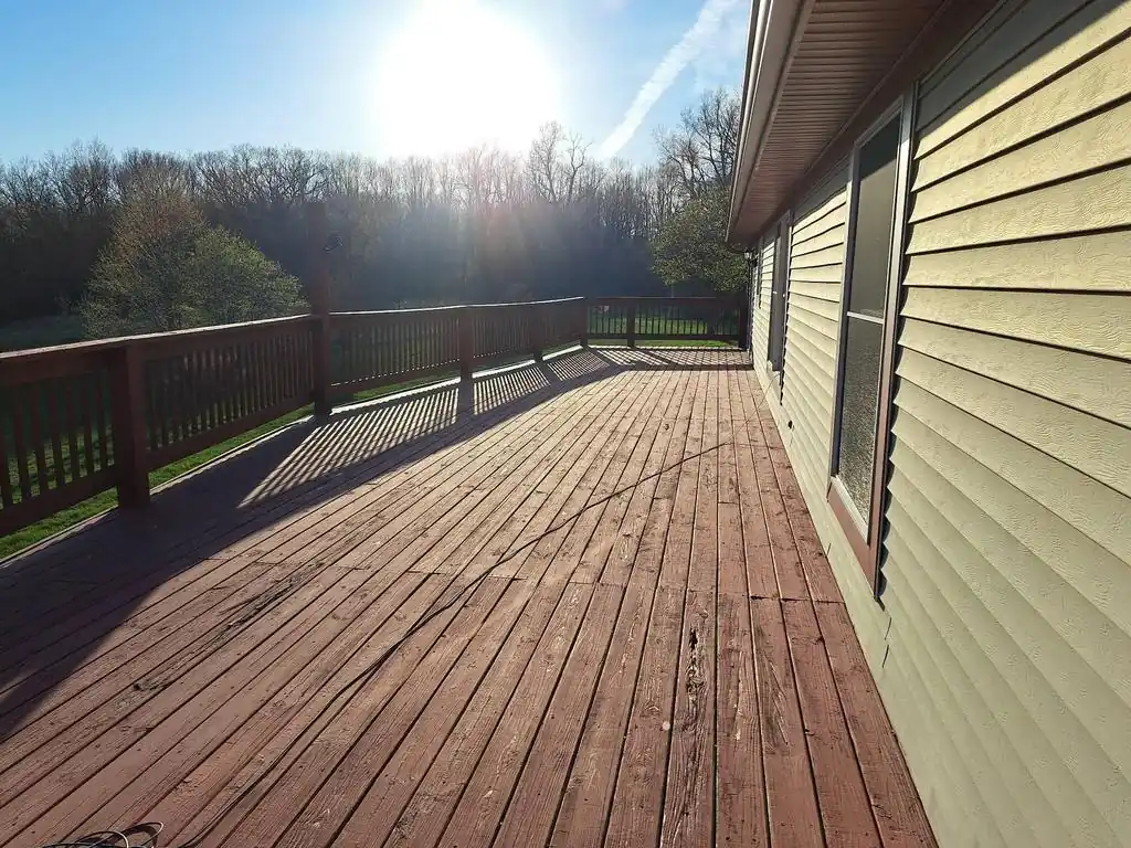 Weathered and peeling wood deck planks requiring replacement by home improvement contractors.