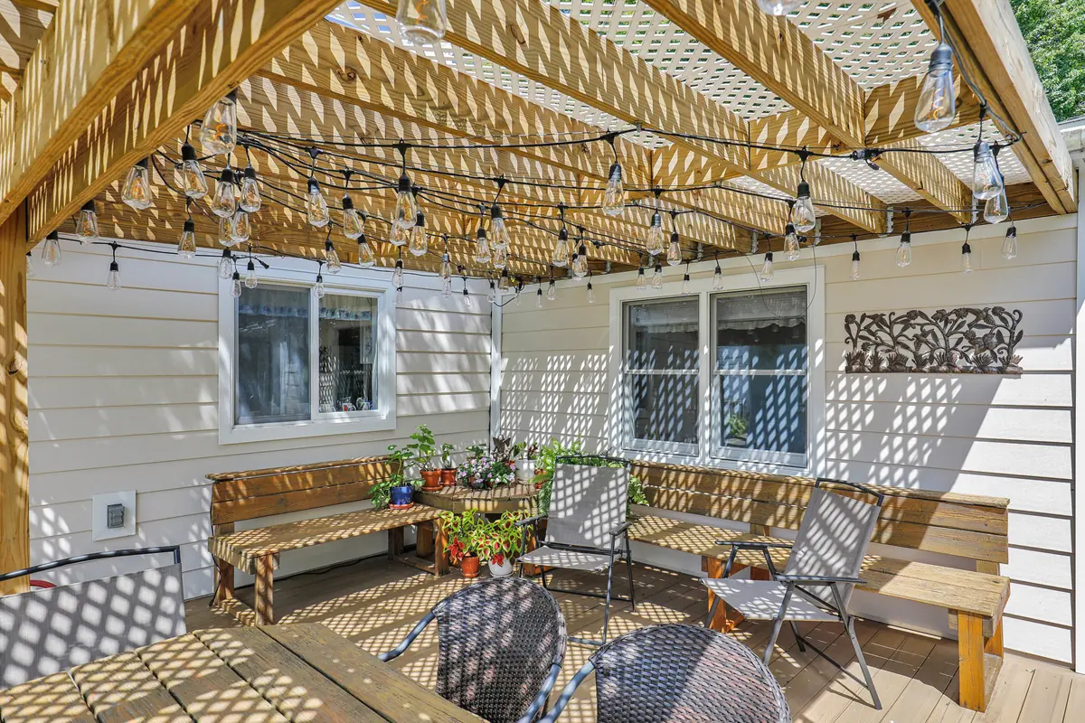 Under-pergola seating area on Trex deck with string lights installed by composite deck contractors.