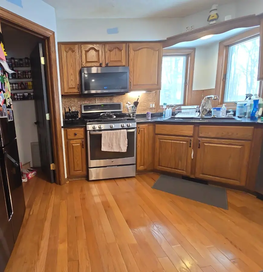 Before kitchen remodel in Brighton MI showing dated honey oak cabinets and older appliances.